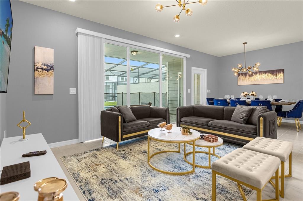 A living room features gray walls, dark sofas, gold accents, and a sliding glass door — 4318 LANA AVENUE, DAVENPORT, FL