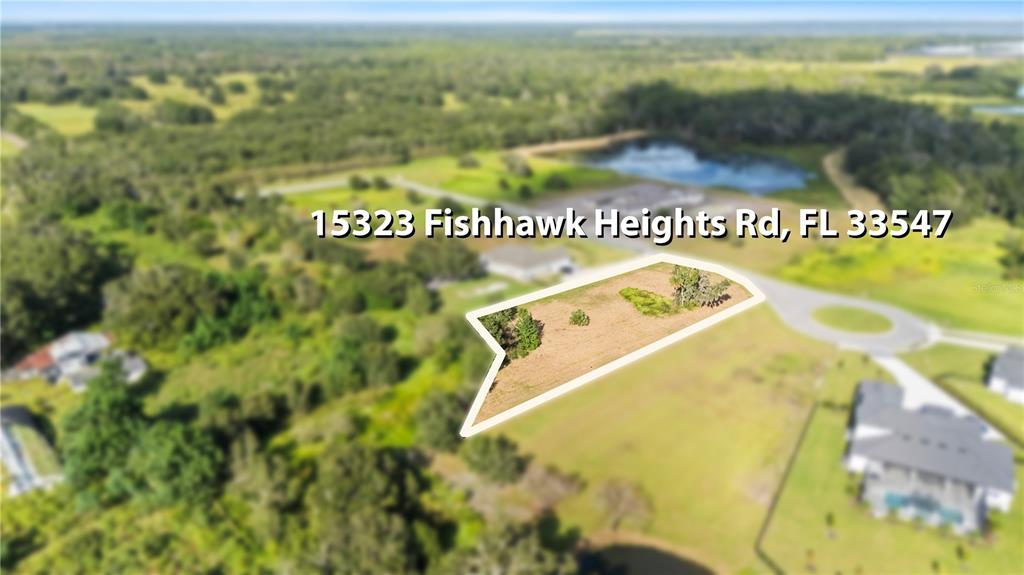 An aerial view shows a vacant, irregularly shaped residential lot in a suburban neighborhood — 15323 FISHHAWK HEIGHTS RUN, LITHIA, FL