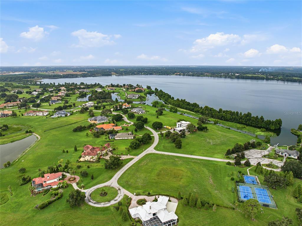 An aerial view shows a large white house with a pool and tennis courts nearby — 10734 OSPREY LANDING WAY, THONOTOSASSA, FL