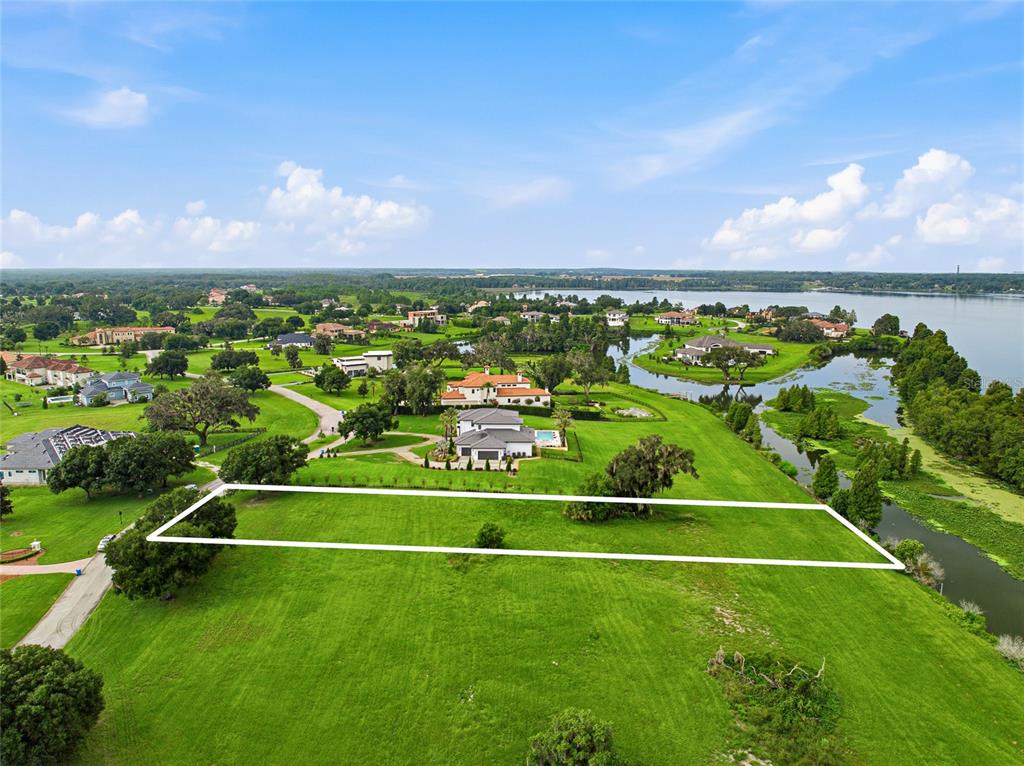An aerial view shows a rectangular plot of land outlined in white on a grassy field — 10734 OSPREY LANDING WAY, THONOTOSASSA, FL