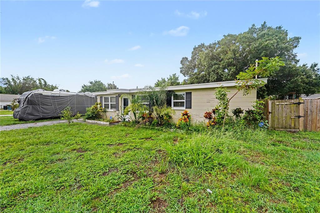 A single-story house with light-colored siding, a front yard, and a covered trailer nearby — 8490 92ND TER, SEMINOLE, FL