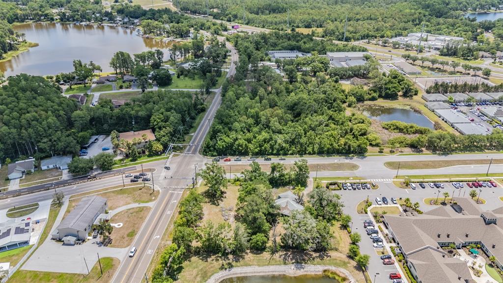 An aerial view shows a road intersection, surrounding commercial buildings, and several small ponds — 18950 SUNLAKE BOULEVARD, LUTZ, FL
