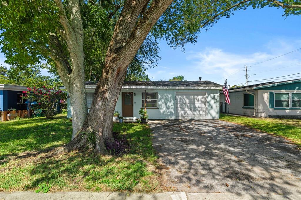 A single-story house with a light-colored exterior, a garage, and a large tree in front — 2608 ANASTASIA DRIVE, SOUTH DAYTONA, FL
