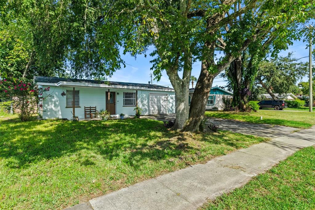 A single-story light blue house with a front lawn, large tree, and concrete driveway — 2608 ANASTASIA DRIVE, SOUTH DAYTONA, FL