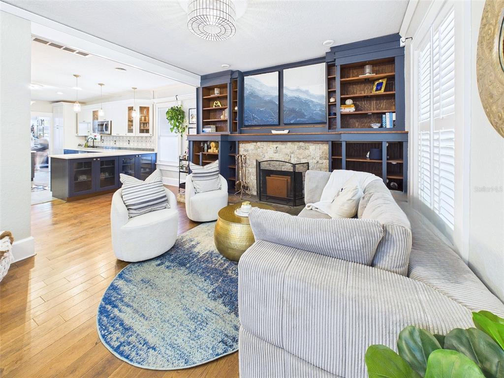 A living room with a stone fireplace, built-in blue shelving, and a circular blue rug — 616 15TH STREET N, ST PETERSBURG, FL