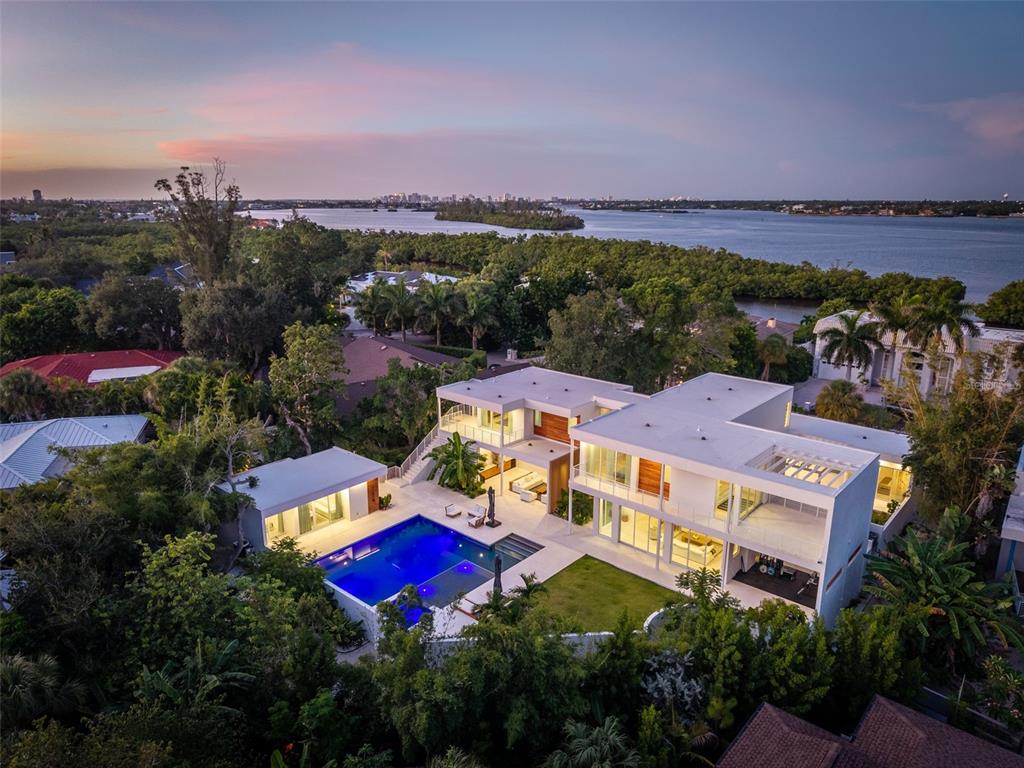 An aerial view of a modern white multi-story house with a pool and waterfront views — 1355 ROBERTS BAY LANE, SARASOTA, FL
