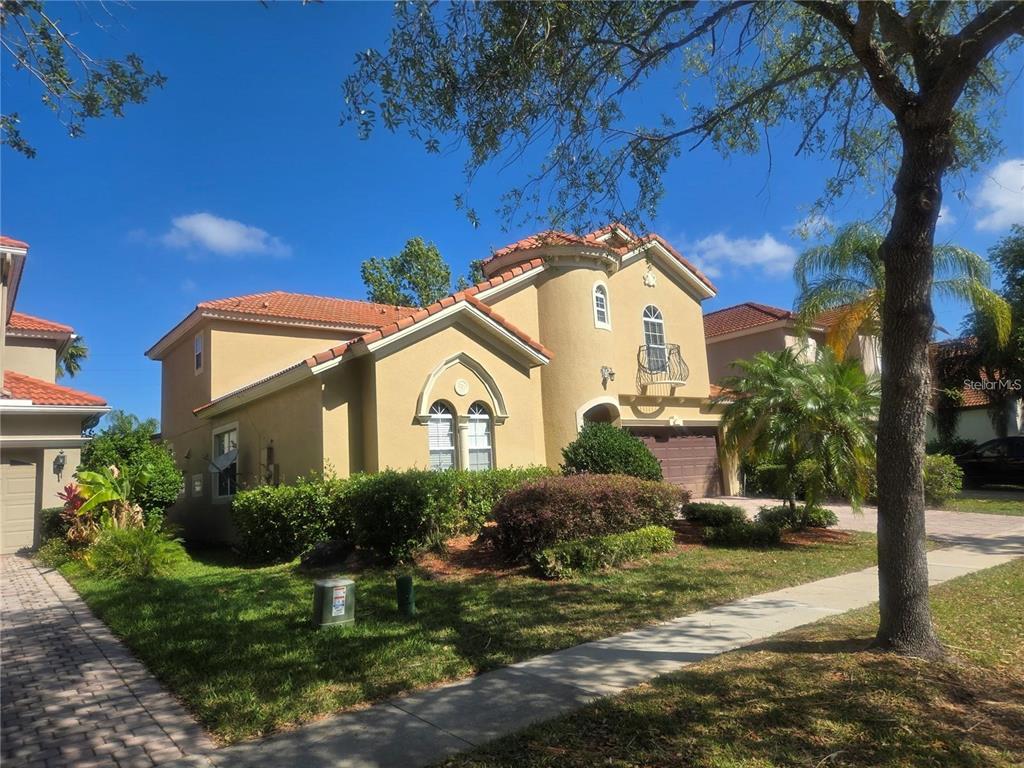A two-story tan stucco house with a tile roof and a front-facing balcony — 1125 LASCALA DRIVE, WINDERMERE, FL