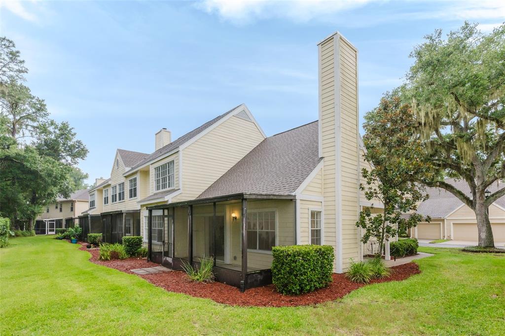 A two-story yellow townhouse with a screened-in porch and a tall chimney — 3614 PINE KNOT DRIVE UNIT 3614, VALRICO, FL