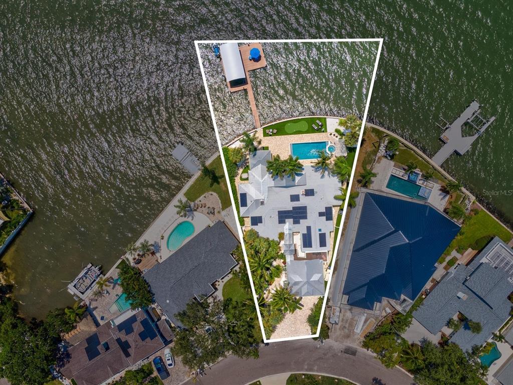 Aerial view of a waterfront house with a pool, putting green, and private boat dock — 1828 VENETIAN POINT DRIVE, CLEARWATER, FL