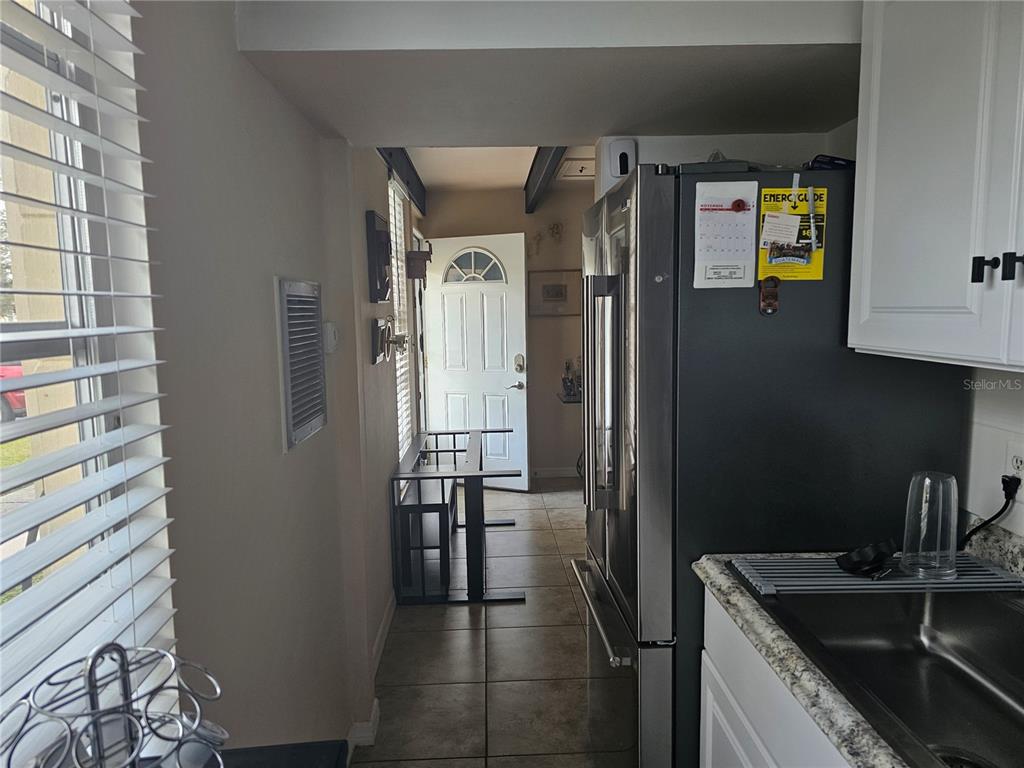 A kitchen features white cabinets, stainless steel appliances, granite countertops, and decorative plates on display — 915 CLUB CIRCLE, LAKESHORE, FL