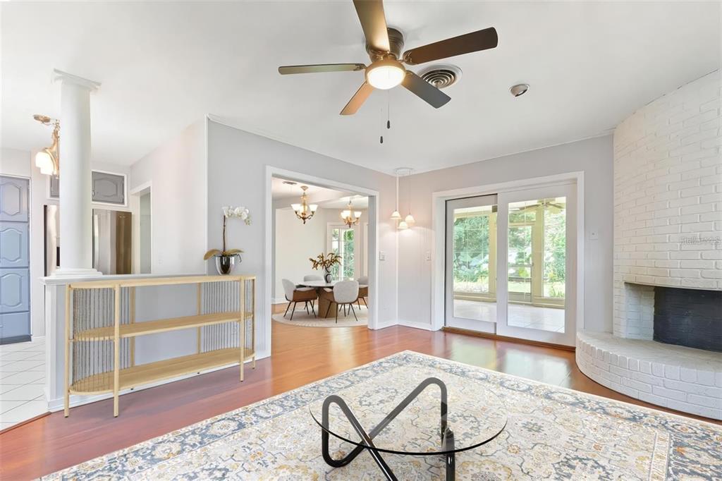 A living room features a white brick fireplace, hardwood floors, and a glass coffee table — 2102 W KYRA DRIVE, TAMPA, FL