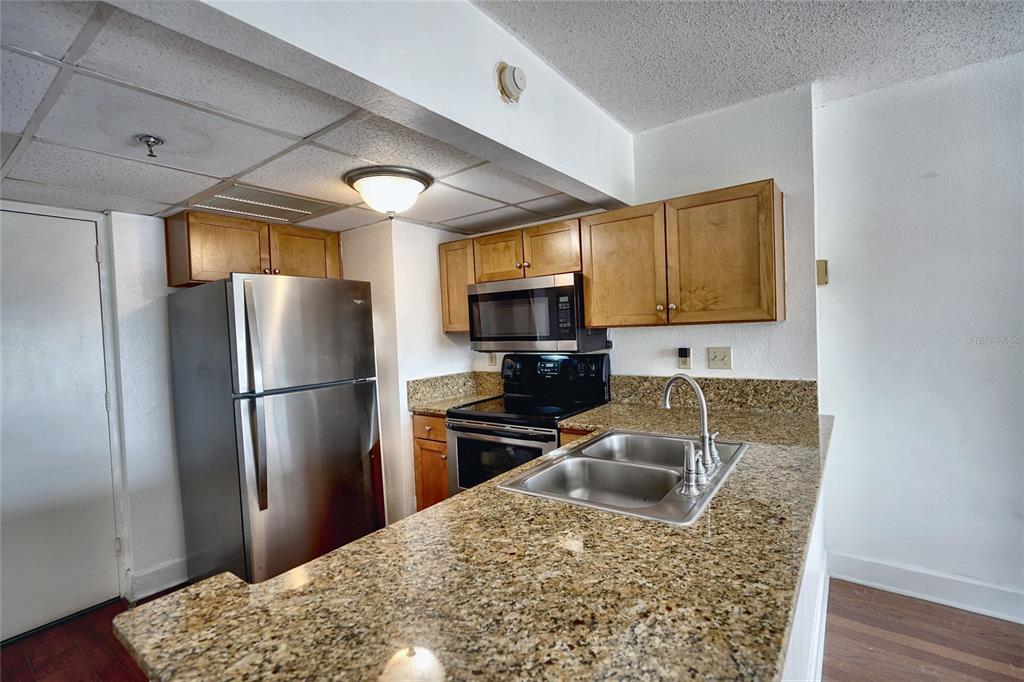 A modern lobby features a seating area, tiled floors, and a staircase with glass railings — 151 E WASHINGTON STREET UNIT 525, ORLANDO, FL