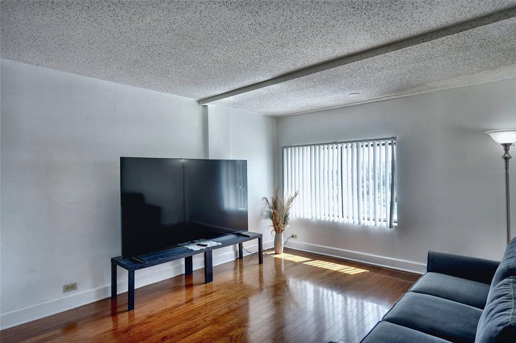A kitchen features stainless steel appliances, wood cabinets, and granite countertops with a double sink — 151 E WASHINGTON STREET UNIT 525, ORLANDO, FL