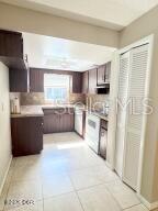 A kitchen features dark wood cabinets, light tile flooring, and a white stove — 228 COLOMBA ROAD, DEBARY, FL