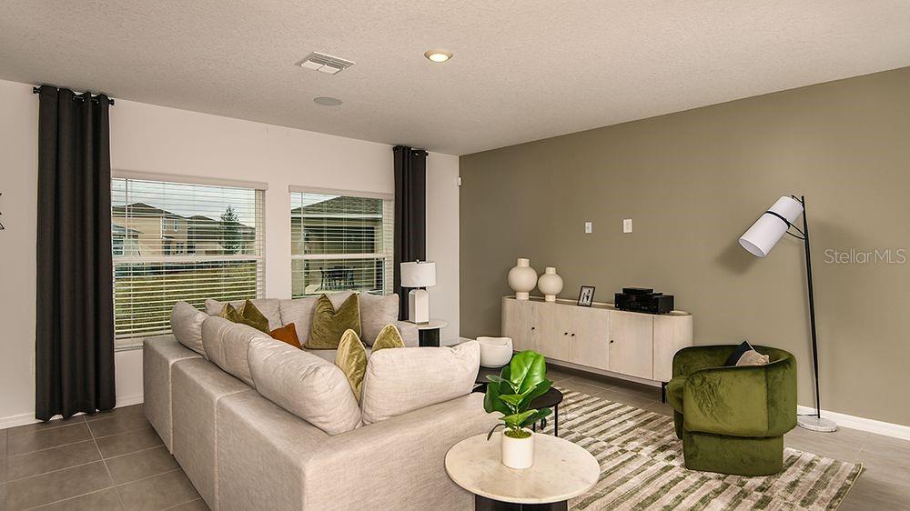 A living room features a large sectional sofa, a green armchair, and a long sideboard — 6512 EQUINOX LANE, NORTH FORT MYERS, FL