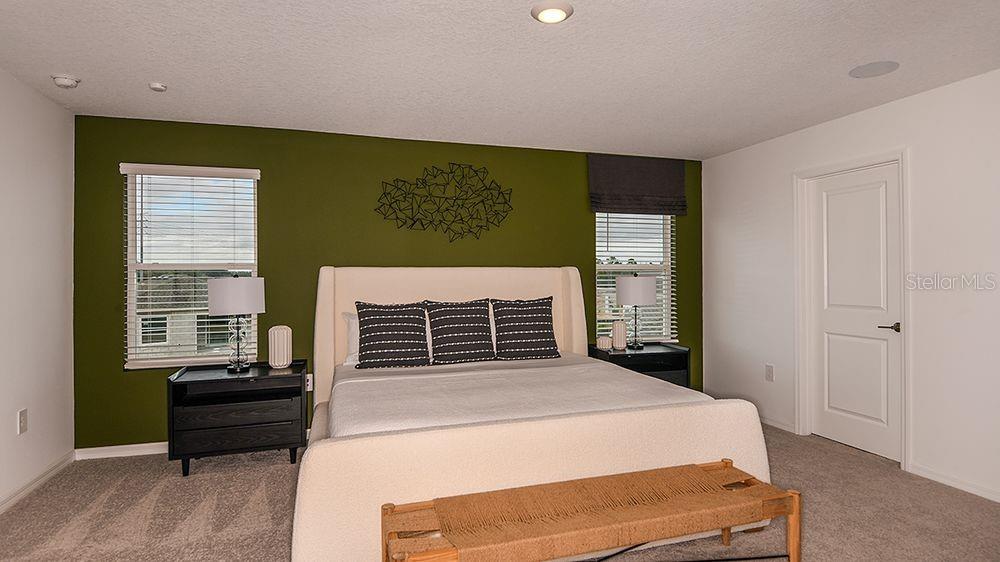 A bedroom features a green accent wall, a light-colored bed, and two black nightstands — 6512 EQUINOX LANE, NORTH FORT MYERS, FL