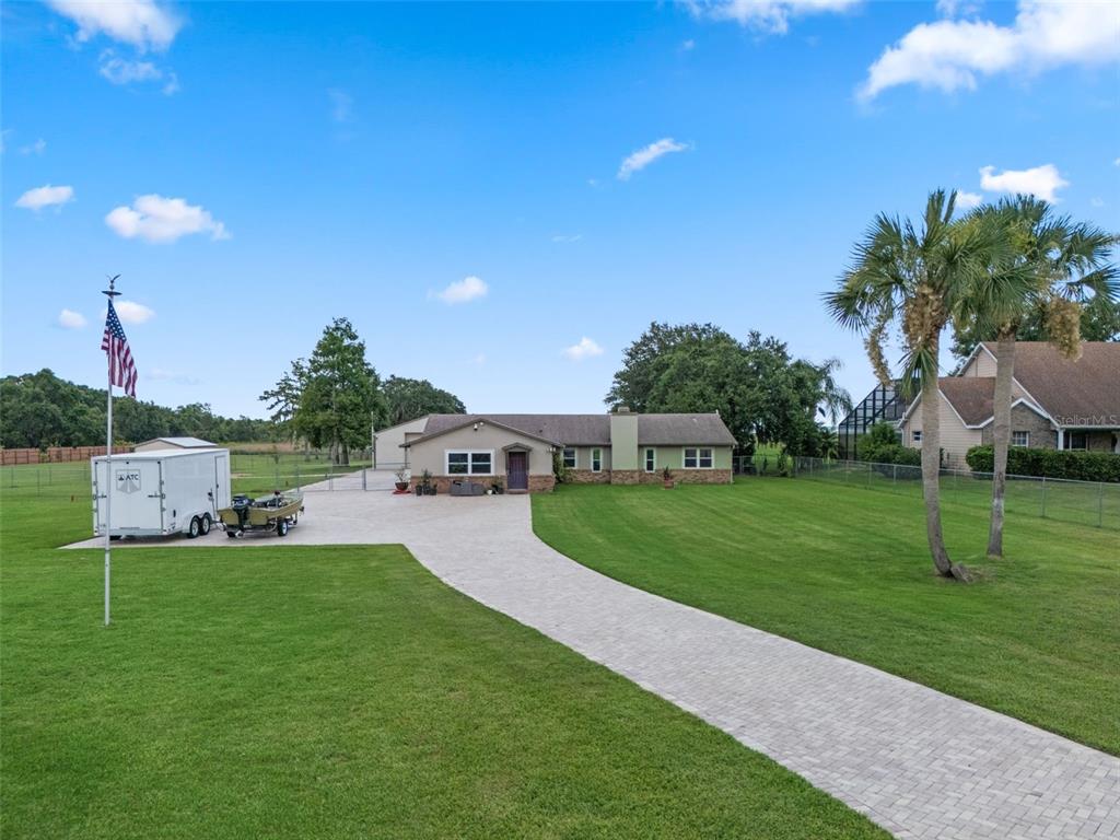 A single-story house with a paved driveway, a trailer, and a boat on a lawn — 2921 LAKE TOHOPEKALIGA BOULEVARD, KISSIMMEE, FL