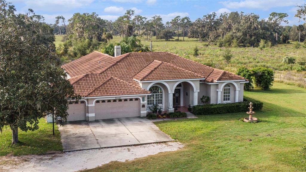 An aerial view of a single-story house with a tile roof and a concrete driveway — 331 LEWIS ROAD, LITHIA, FL