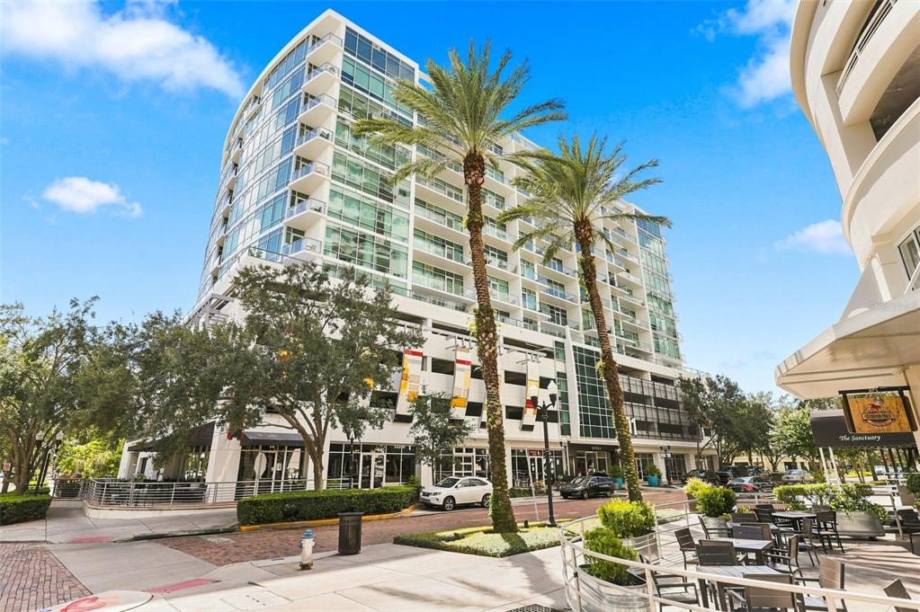 A multi-story modern apartment building with glass balconies and palm trees in front — 101 S EOLA DRIVE UNIT 905, ORLANDO, FL