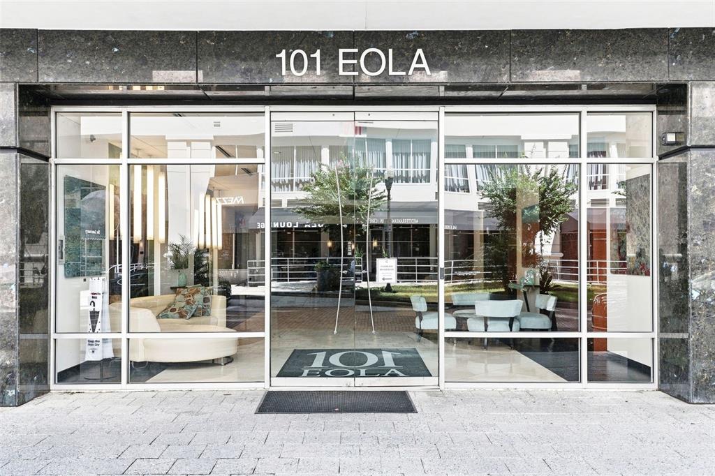 The exterior entrance of a building features glass double doors and large windows — 101 S EOLA DRIVE UNIT 905, ORLANDO, FL