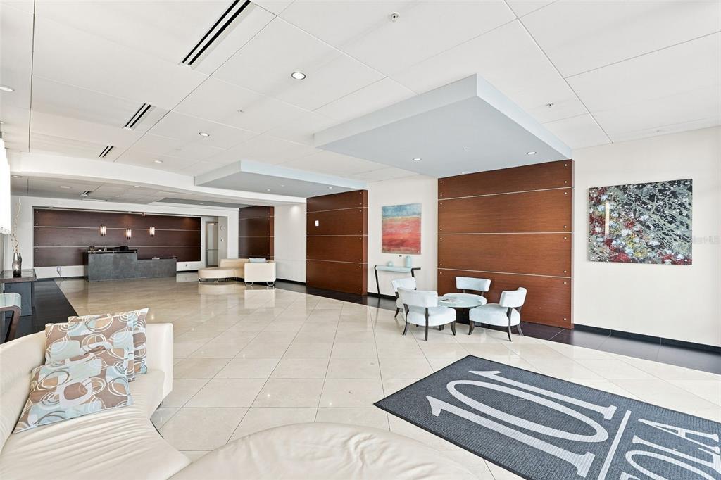 A spacious office lobby features a reception desk, seating areas, and light-colored tile flooring — 101 S EOLA DRIVE UNIT 905, ORLANDO, FL