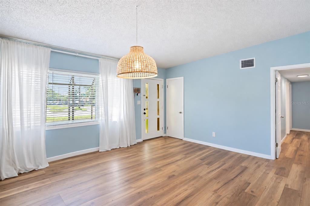 A dining area with a wooden hutch, round table, and open view into the kitchen — 1840 N POWERS DRIVE, ORLANDO, FL