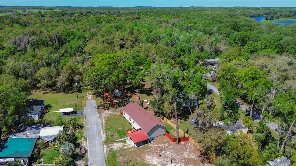 An aerial view shows a residential property with a long house surrounded by dense trees — 28477 SENTINEL STREET, NOBLETON, FL