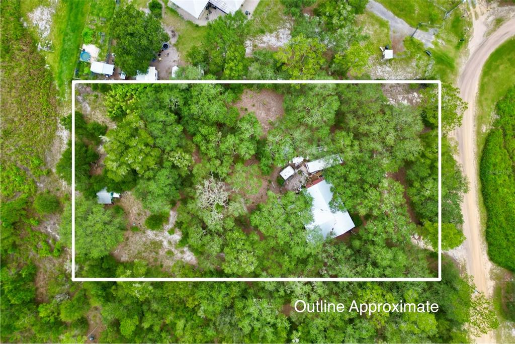 An aerial view shows a wooded lot with a house and outbuildings within a white border — 5816 BRYCE STREET, KEYSTONE HEIGHTS, FL