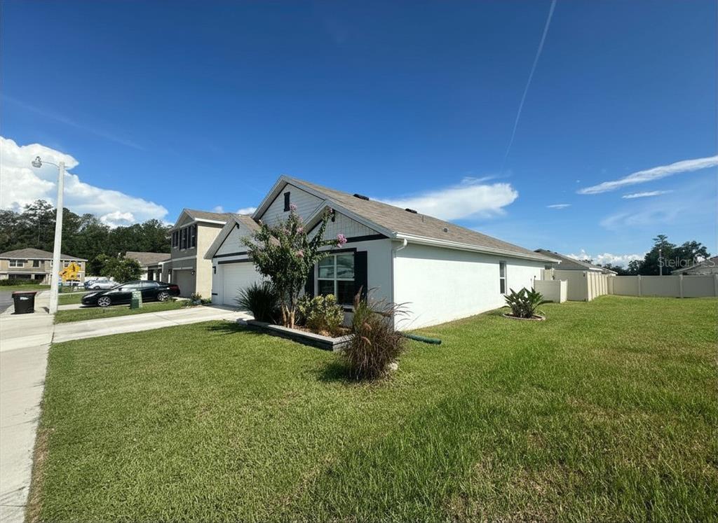 A white single-story house with a driveway and a green lawn under a blue sky — 6830 SE 3RD LOOP, OCALA, FL