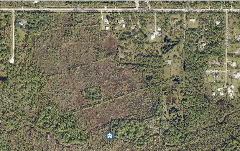 An aerial view shows a large, wooded plot of land bordered by roads — NO NAME, GRANT, FL