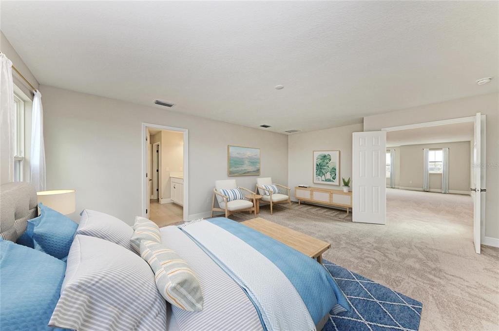 A spacious bedroom features a king bed, two armchairs, and an adjacent sitting area — 13718 HEARTWOOD WAY, PARRISH, FL