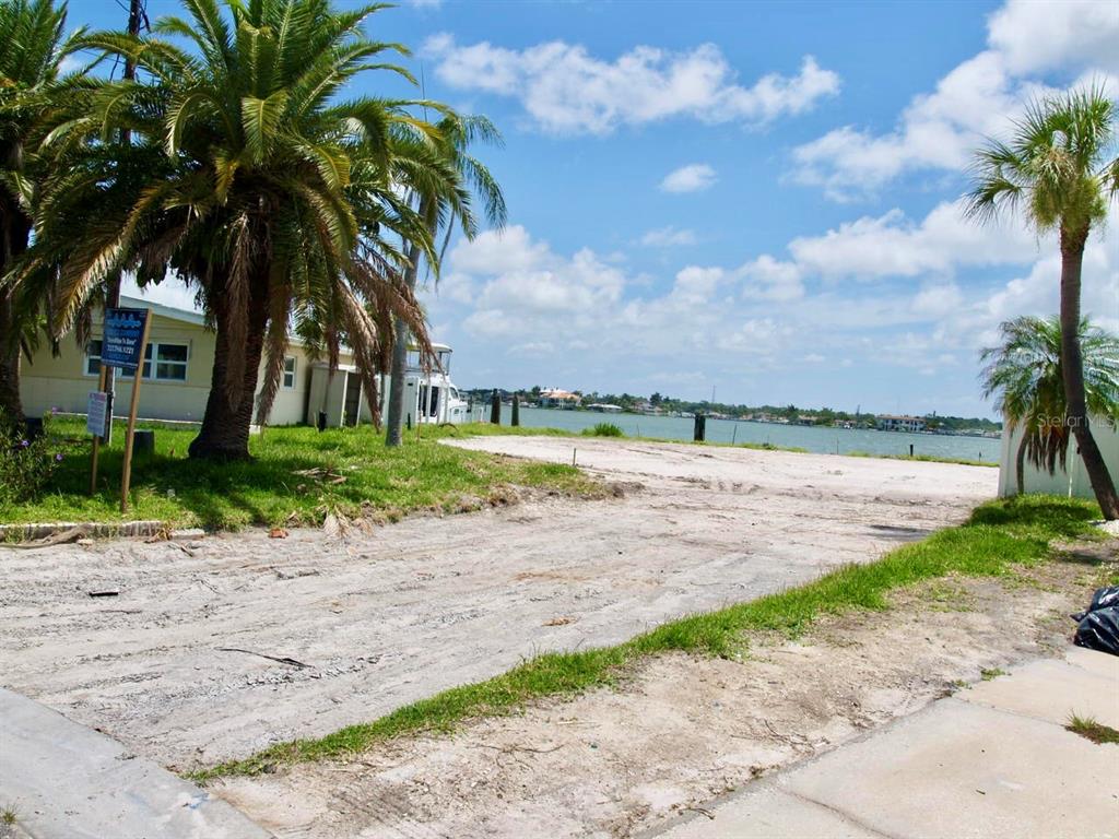 A vacant, sandy waterfront lot features palm trees and a view of the bay — 16003 5TH STREET E, REDINGTON BEACH, FL