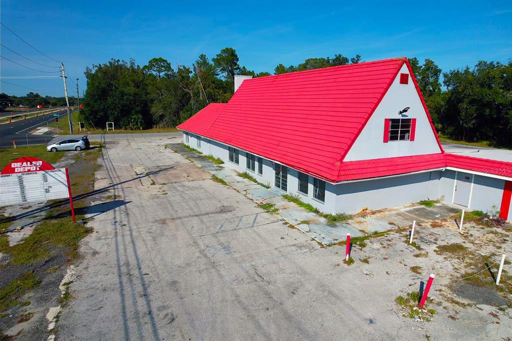 An aerial view of a commercial building with a prominent red roof and parking lot — 4795 US-1 HIGHWAY, MIMS, FL