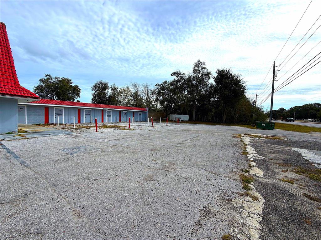 A single-story commercial building with a red roof and gray exterior sits by a parking lot — 4795 US-1 HIGHWAY, MIMS, FL