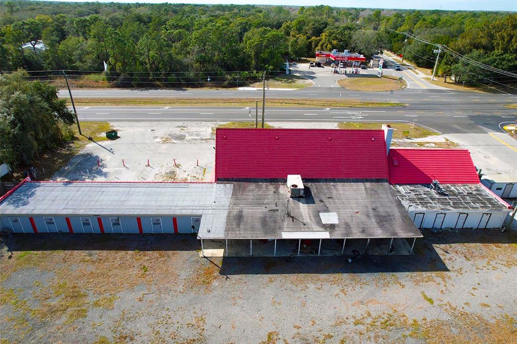 An aerial view shows a commercial building with a red roof next to a highway — 4795 US-1 HIGHWAY, MIMS, FL