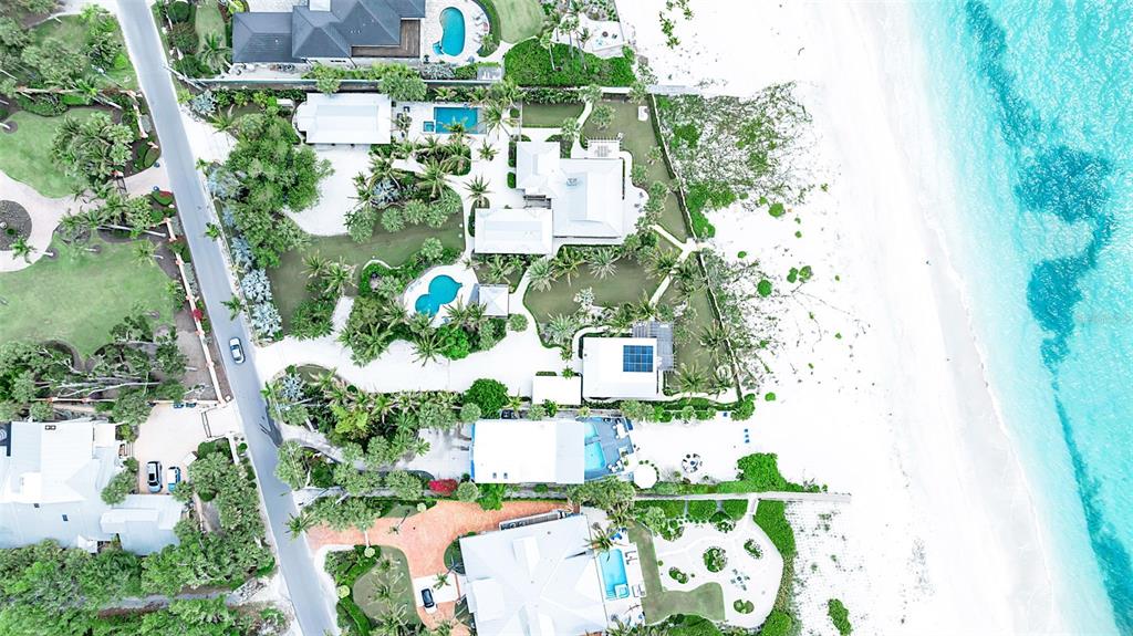 Aerial view of several beachfront properties with swimming pools and lush landscaping along the coast — 621 CASEY KEY ROAD, NOKOMIS, FL
