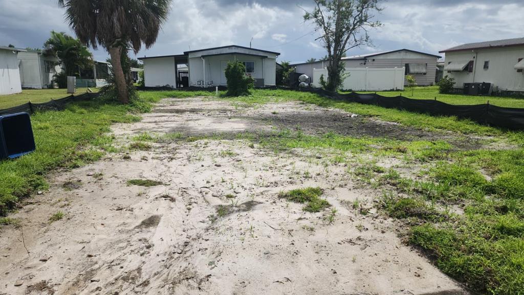 A vacant, sandy residential lot sits between two manufactured homes in a mobile home park — 306 50TH AVENUE PLAZA E, BRADENTON, FL