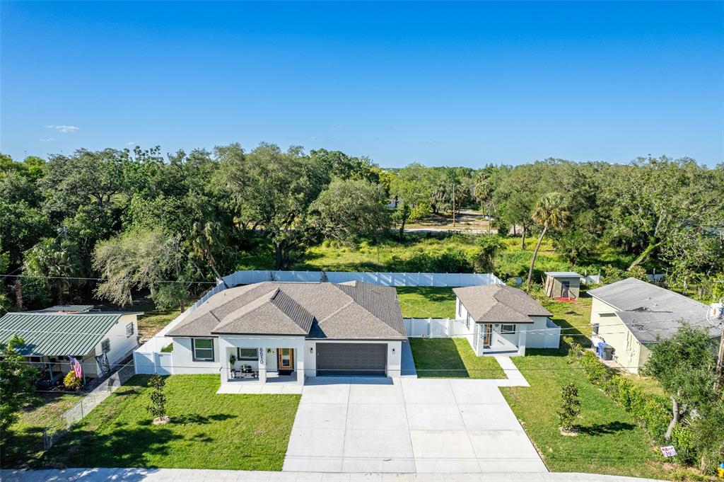 An aerial view shows a modern house with a garage and a detached guest cottage — 6510 E 25TH AVENUE, TAMPA, FL