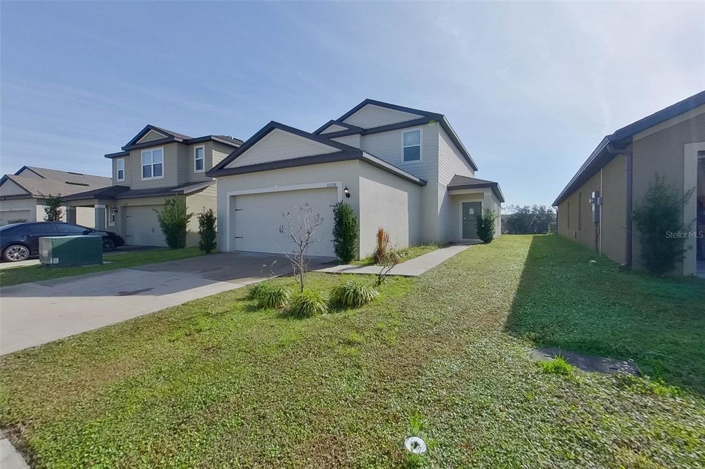 A two-story suburban house with a two-car garage and a front lawn — 30098 FEDORA CIRCLE, BROOKSVILLE, FL