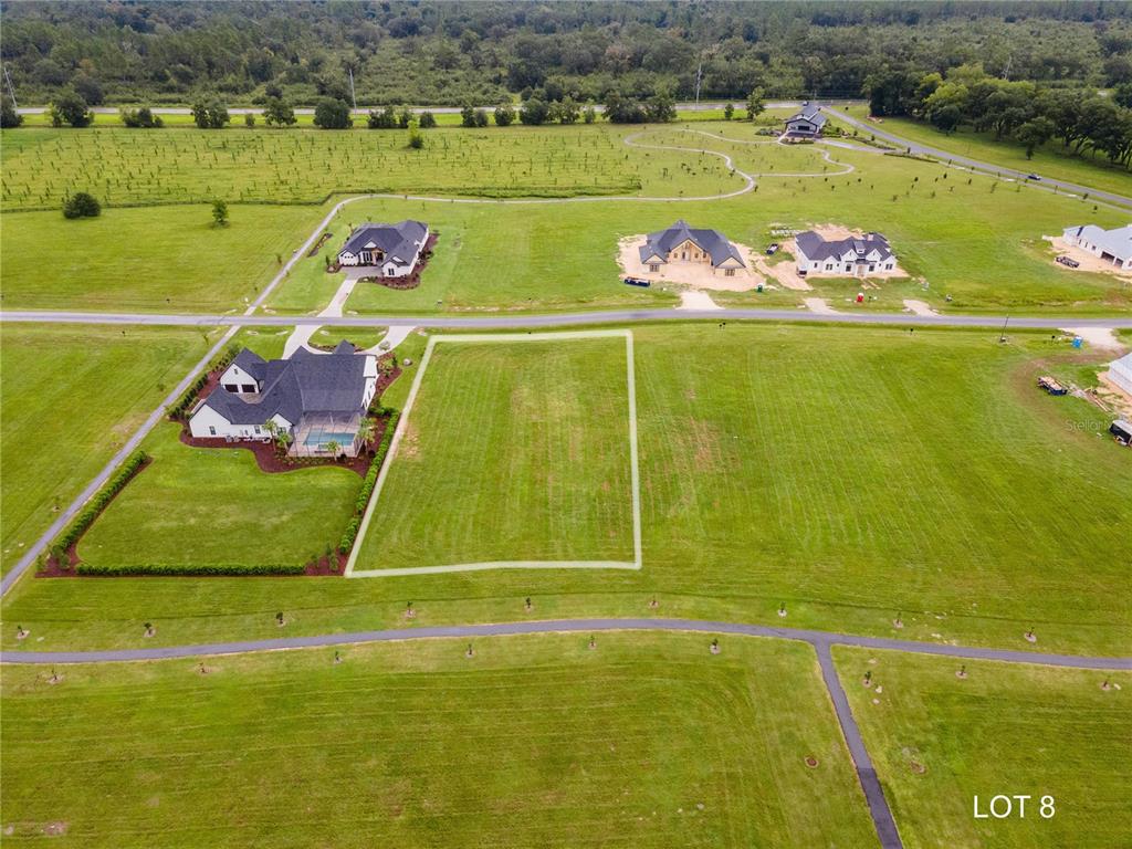An aerial view shows a vacant rectangular residential lot outlined in white near existing homes — 5118 SW 125TH CIRCLE, ARCHER, FL