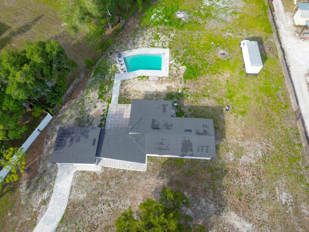 An aerial view shows a house with a dark roof, a pool, and a shed — 1602 S TANNER ROAD, ORLANDO, FL