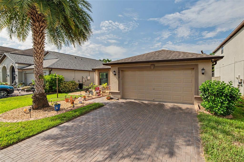 A paved walkway leads to the front entrance of a house with a bay window — 14219 STOCKWELL LANE, RUSKIN, FL