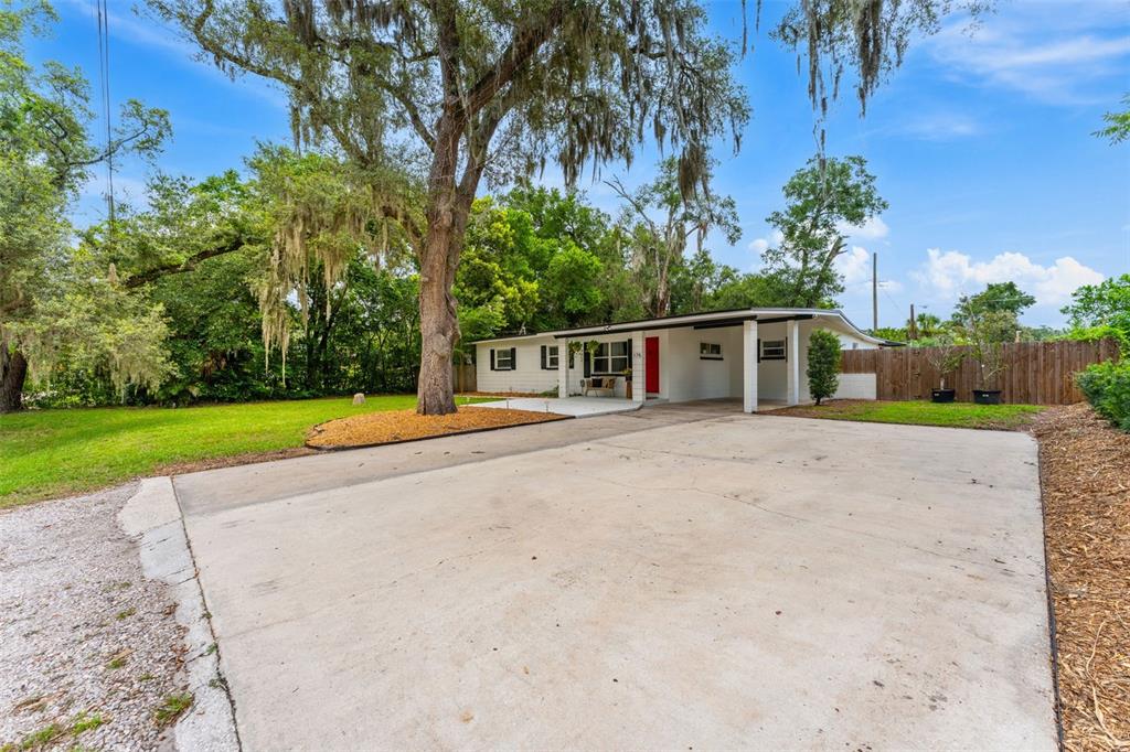 A single-story white house with a red front door and a large concrete driveway — 175 GRACE BOULEVARD, ALTAMONTE SPRINGS, FL