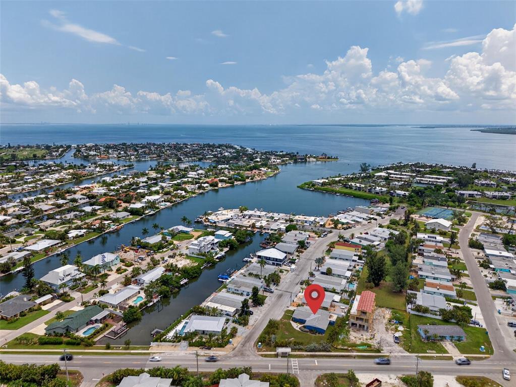 An aerial view shows a coastal neighborhood with a red pin marking a specific house — 401 63RD STREET, HOLMES BEACH, FL