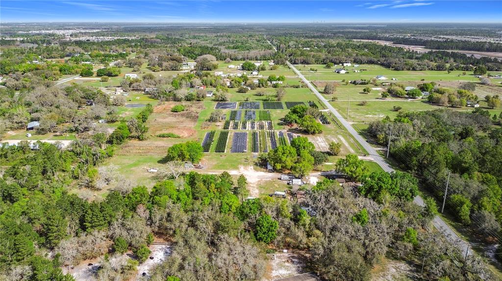 An aerial view shows a rural property with a plant nursery and surrounding wooded areas — 2360 ABSHER ROAD, ST CLOUD, FL
