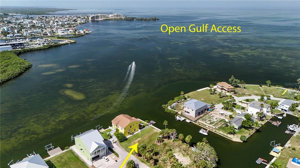 An aerial view shows a yellow house on a waterfront lot with open gulf access — 0 SEAVIEW BOULEVARD, HUDSON, FL