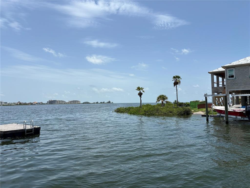 A view of a waterfront property with a dock, a boat, and palm trees — 0 SEAVIEW BOULEVARD, HUDSON, FL