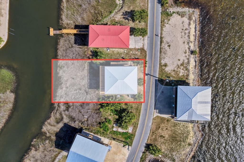 An aerial view shows a house with a white roof highlighted by a red rectangle — 19018 GOOD TIMES DRIVE, PERRY, FL