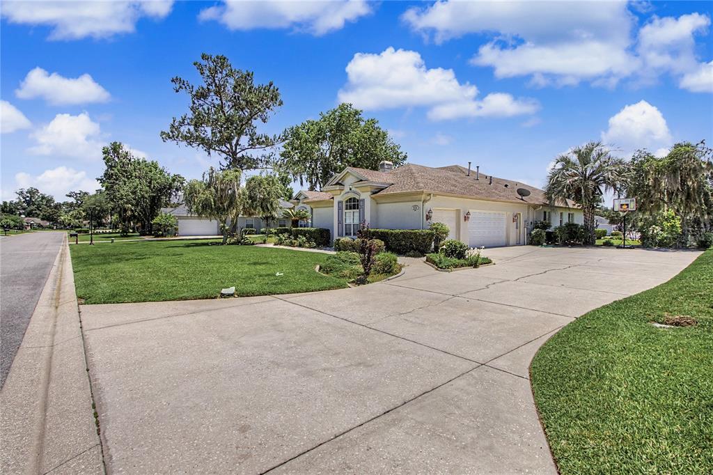 A single-story house with a large concrete driveway, a two-car garage, and a green lawn — 2114 SE 25TH LOOP, OCALA, FL