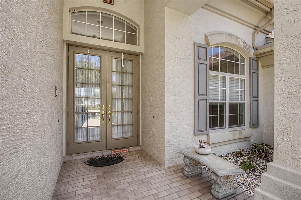 A front entryway features double glass doors, a stone bench, and a window with shutters — 2114 SE 25TH LOOP, OCALA, FL